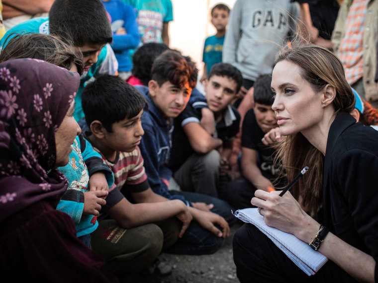 Image: Handout photo of UNHCR Special Envoy Angelina Jolie speaking with Syrian refugees in a Jordanian military camp based near the Syria-Jordan border